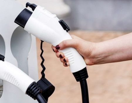 Hand holding an electric car charger